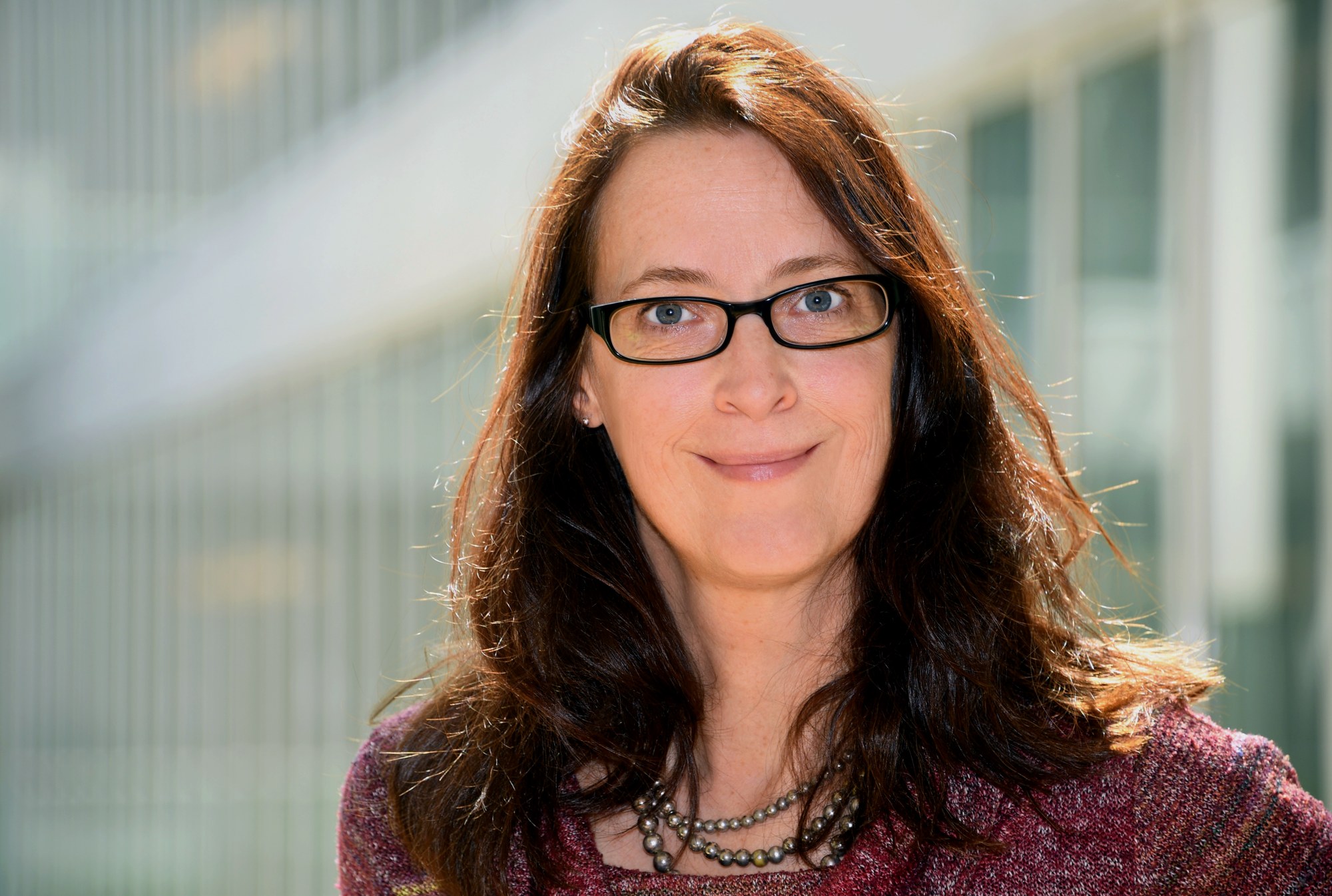 Porträt der lächelnden Altersforscherin Daniela Jopp mit dunkler Brille