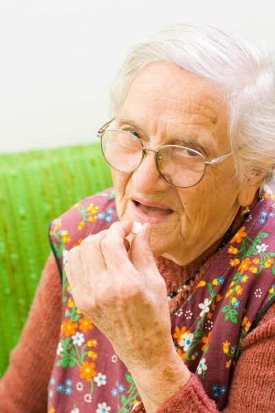 Alte Dame nimmt Medikament ein