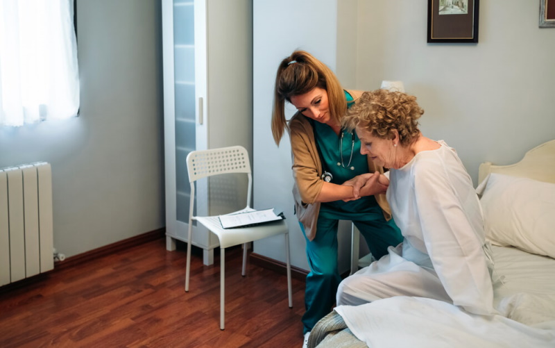 Krankenschwester hilft Patientin beim Aufstehen