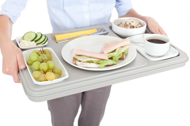 Eine Frau trägt ein Tablett mit Essen