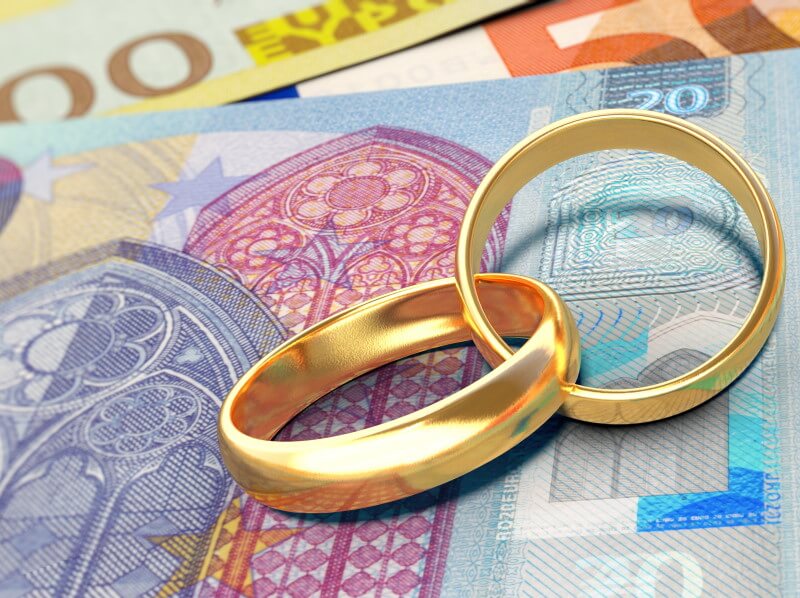 Güterstand: Zwei Eheringe auf ein paar Euro-Geldscheinen