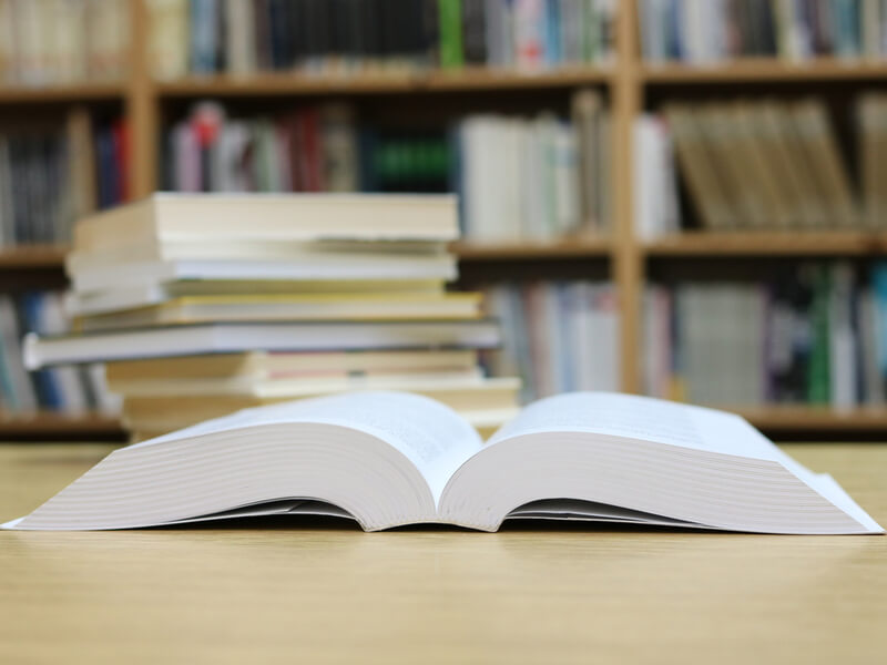 Aufgeschlagenes Buch auf dem Tisch in einer Bibliothek