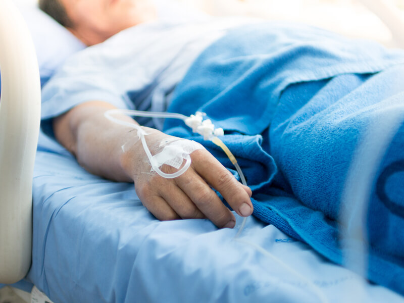 Hand eines Patienten im Krankenhausbett