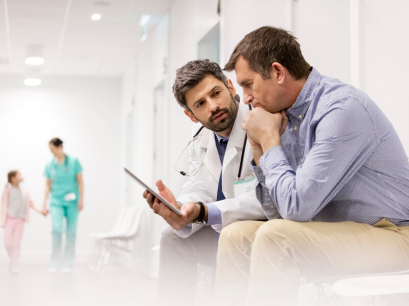 Arzt im Krankenhaus spricht mit dem Angehörigen eines Patienten